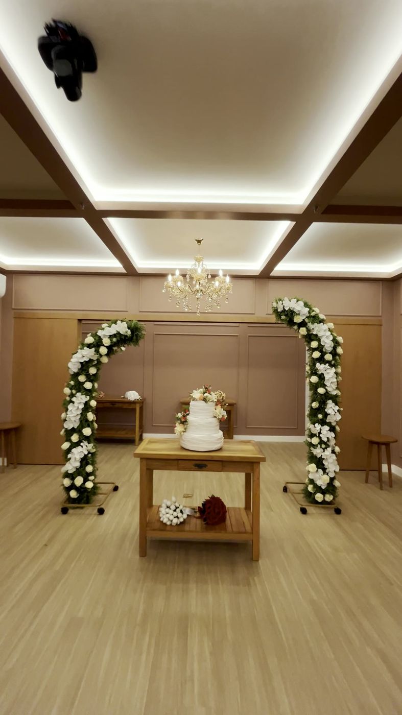 Corredor até o altar com arcos de flores e bolo