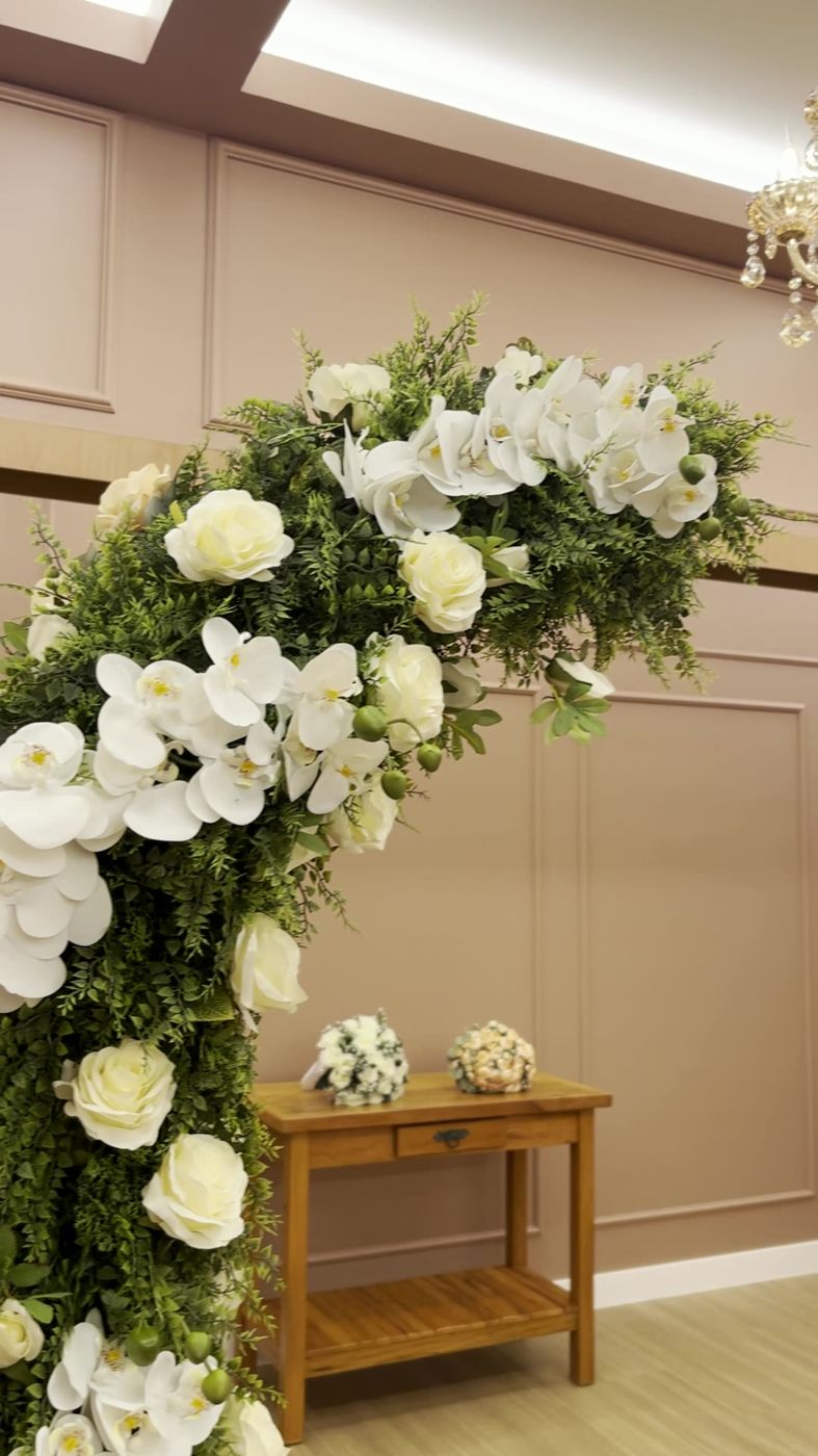 Arco de flores brancas no altar do salão